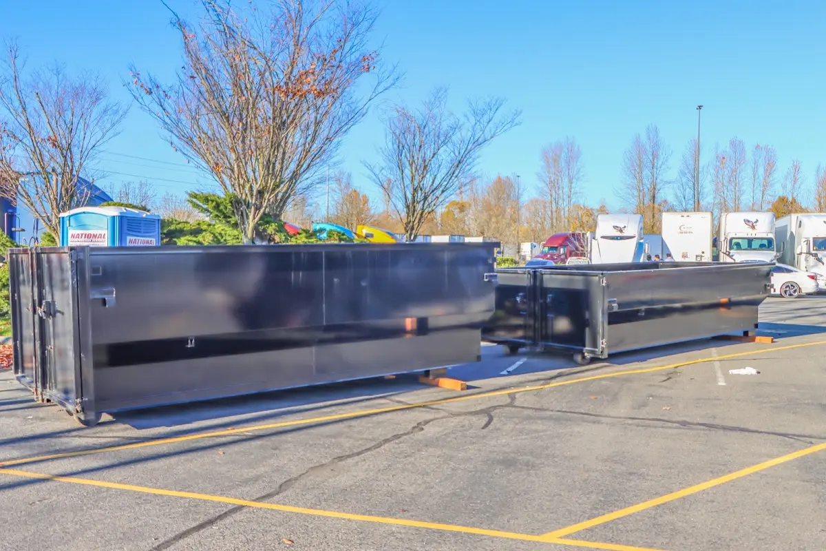 Professional dumpster rental service with roll-off container on residential driveway in Weehawken